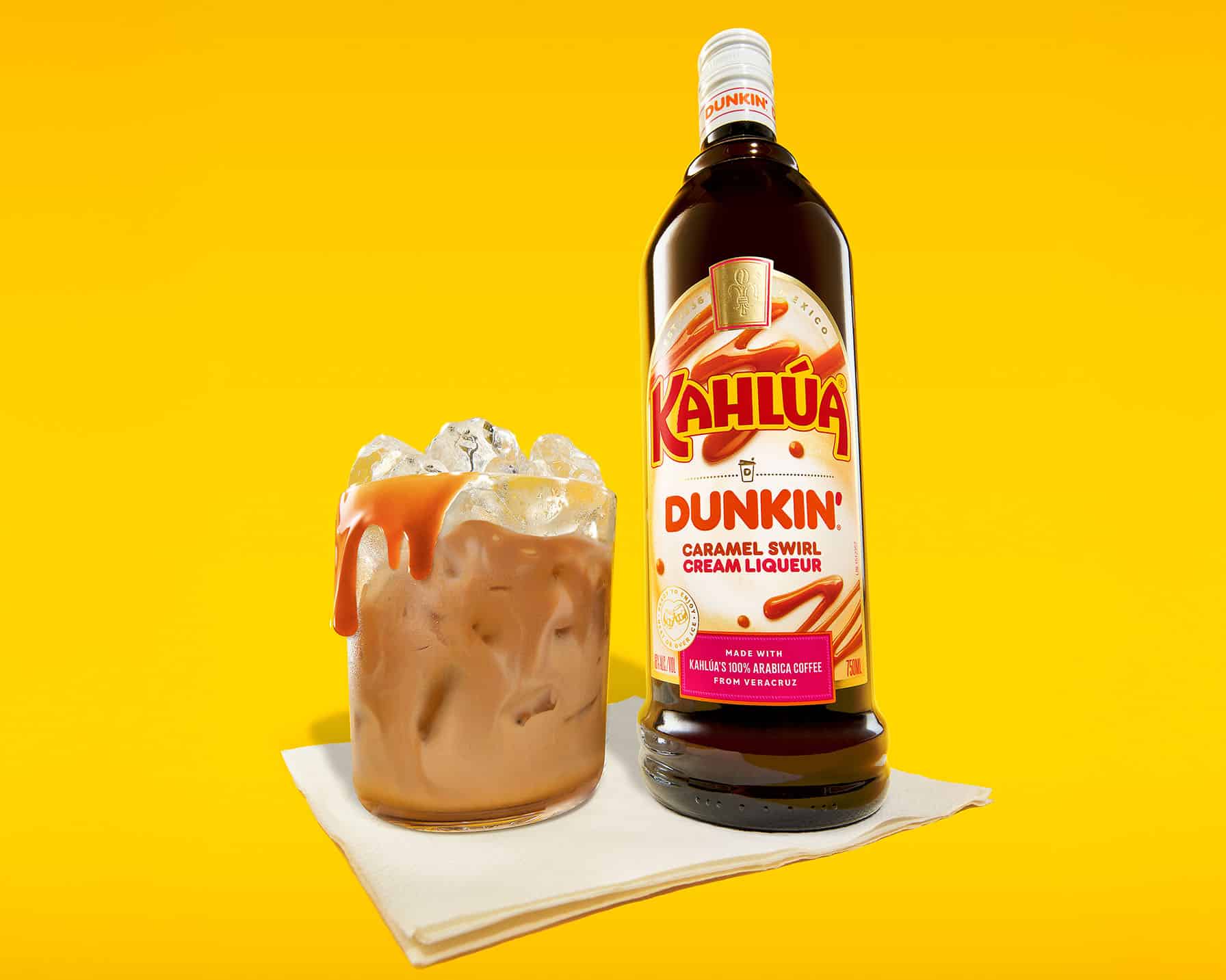 Dunkin' Kahlúa Caramel Swirl Cream liqueur next to a drink over ice